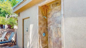 A spa area with a shower, a door, and a seating area with sun loungers. - 5BR with deck, grill, fireplace, pool, & hot tub (St. George)