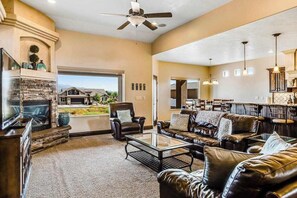 A spacious living room with leather sofas, a fireplace, and a television. - Lovely 4BR Mountainview Zion National Park (Hurricane)