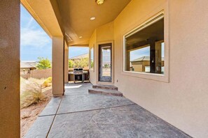 A covered outdoor area with a patio, a barbecue grill, and a door leading to a covered space. - Lovely 4BR Mountainview Zion National Park (Hurricane)