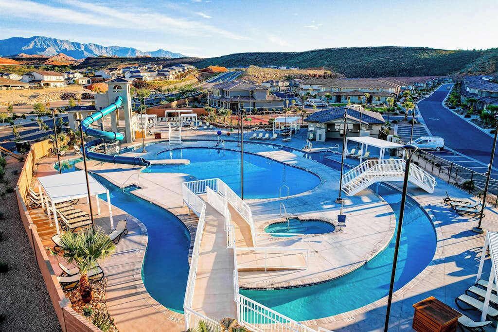 Un resort con una piscina grande, un tobogán acuático y vistas del paisaje circundante.