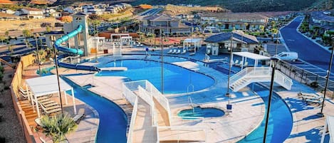 Un resort con una piscina grande, un tobogán acuático y vistas del paisaje circundante.