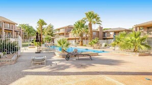 A hotel pool area with lounge chairs, palm trees, and a clear blue sky. - Sunny 2BR Mountainview Zion National Park (St. George)