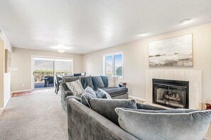 A living room with a fireplace, a sofa set, and a dining area with a view. - Sunny 2BR Mountainview Zion National Park (St. George)