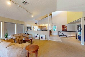 A spacious living area with a sofa, coffee table, and a small table. There are two speakers and a plant in the room. - 1 BR condo withshared pools, sports courts (Saint George)