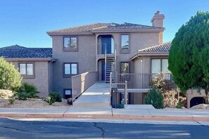 A two-story house with a front entrance, a staircase, and a small porch. - 1 BR condo withshared pools, sports courts (Saint George)