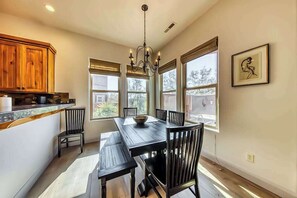 A dining area with a black table and chairs, wooden cabinets, and a chandelier. - Lovely 3BR Mountainview Zion National Park 2nd-fl (Santa Clara)