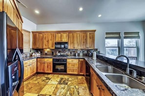 A kitchen with wooden cabinets, a stainless steel sink, and a tiled floor. - Lovely 3BR Mountainview Zion National Park 2nd-fl (Santa Clara)