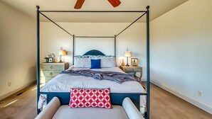 Un letto a baldacchino con testiera, comodini e lampade.