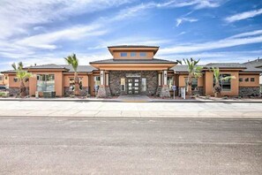 A hotel with a stone facade, a flat roof, and palm trees in front. - Townhouse with resort amenities, private hot tub (Hurricane)