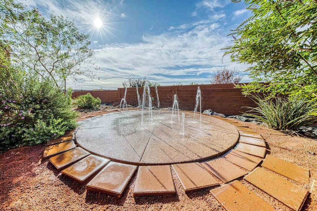 A circular outdoor area with a central water feature surrounded by a circular seating arrangement.
