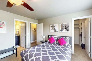 A bedroom with a bed, a bench, a ceiling fan, and artwork on the walls. - 3BR townhouse near Zion National Park (Washington)