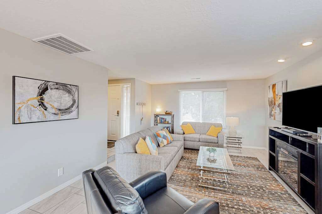 A living room with a sofa, a coffee table, and a television.