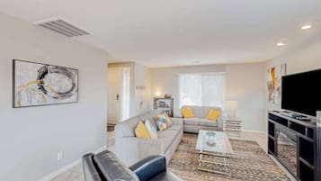 A living room with a sofa, a coffee table, and a television.