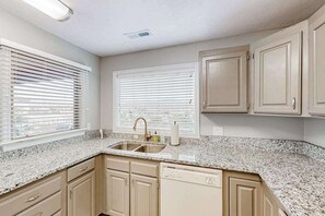 A kitchen with a granite countertop, a double sink, beige cabinetry, and two windows with blinds. - 2BR mtn-view with pools & hot tub - near Zion (St. George)