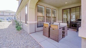 A covered patio with wicker furniture and a grill. - 5BR townhouse with lazy river pool (Washington)