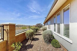 A building with a paved pathway, a metal railing, and trimmed bushes. - 3BR townhouse with hot tub and heated pool (Washington)