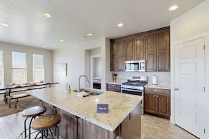 A kitchen with a large island, wooden cabinets, and a stainless steel oven. - 3BR townhouse with hot tub and heated pool (Washington)