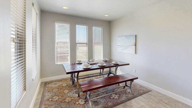 A dining area with a table set for four, a bench, and a patterned rug. - 3BR townhouse with hot tub and heated pool (Washington)