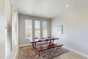 A dining area with a table set for four, a bench, and a patterned rug. - 3BR townhouse with hot tub and heated pool (Washington)