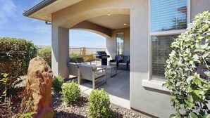 A covered patio area with outdoor furniture, a barbecue grill, and a view of the surrounding landscape. - 3BR townhouse with hot tub and heated pool (Washington)