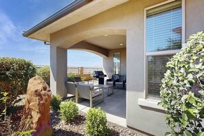 A covered patio area with outdoor furniture, a barbecue grill, and a view of the surrounding landscape. - 3BR townhouse with hot tub and heated pool (Washington)