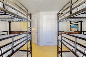 A room with bunk beds, a white door, and a poster on the wall. - Zion Retreat - Townhouse in Washington (Washington)