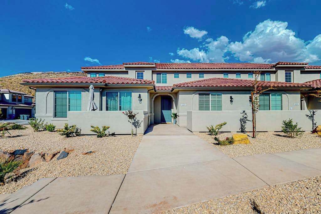 A multi-story residential building with a symmetrical facade, a central entrance, and a gravel driveway.