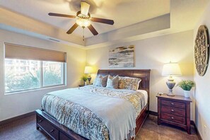 A bedroom with a bed, a ceiling fan, a window, and a nightstand with a lamp. - 3BR condo with pool, hot tub & pickleball court (St. George)