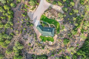 Eine Luftaufnahme einer Anlage mit einem zentralen Gebäude, umgeben von bepflanzten Flächen und vereinzelter Vegetation.