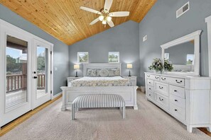 A bedroom with a bed, bedside tables, a dresser, a ceiling fan, and a view through a door. - 4BR home - wrap around porch, fire pit & hot tub (New Harmony)