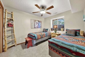A bedroom with two beds, a ceiling fan, a ladder, and a window with a view. - 4BR home - wrap around porch, fire pit & hot tub (New Harmony)