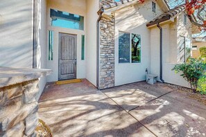 A house with a stone facade, a wooden door, and a window. - 5BR spacious home with pool, hot tub, & foosball (Hurricane)