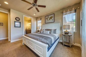 A bedroom with a bed, a ceiling fan, a nightstand, a lamp, and a window with curtains. - Spacious 5BR Mountainview Paradise Village (Santa Clara)