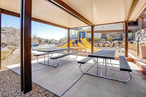 An outdoor patio area with picnic tables and a playground in the background. - 4BR mtn-view townhome with pools, hot tubs, gym (Washington)