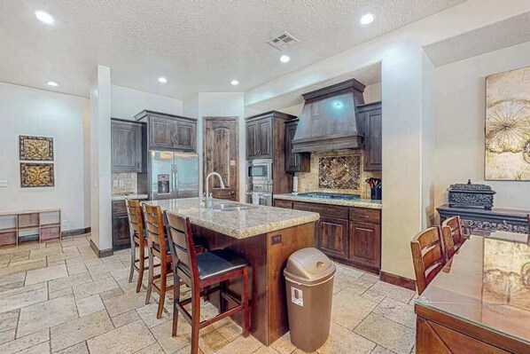 A modern kitchen with dark wood cabinets, a granite countertop island, and a stainless steel range hood. - 4BR mtn-view townhome with pools, hot tubs, gym (Washington)