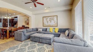 A spacious living area with a sectional sofa, ottomans, a dining table, and chairs. - 4BR mtn-view townhome with pools, hot tubs, gym (Washington)