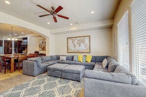 A spacious living area with a sectional sofa, ottomans, a dining table, and chairs. - 4BR mtn-view townhome with pools, hot tubs, gym (Washington)