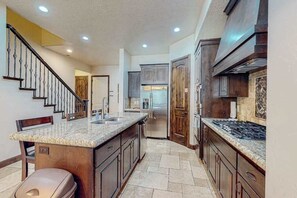 A kitchen with granite countertops, stainless steel appliances, and wooden cabinets. - 4BR mtn-view townhome with pools, hot tubs, gym (Washington)