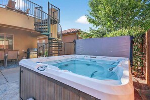 A hot tub in a backyard with a wooden deck, a staircase, and a patio area. - 5BR home with waterpark, private pool and spa (Santa Clara)