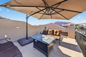 A patio with a table, chairs, and an umbrella. - 5BR home with waterpark, private pool and spa (Santa Clara)