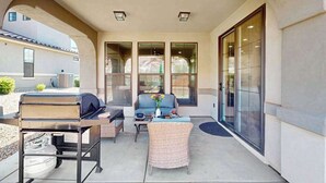 An outdoor patio with a grill, seating, and large windows. - 5BR shared pool with slide near outdoors (Washington)