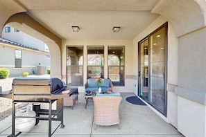 An outdoor patio with a grill, seating, and large windows. - 5BR shared pool with slide near outdoors (Washington)