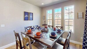 A dining area with a long table set for multiple people, surrounded by chairs. - 5BR shared pool with slide near outdoors (Washington)