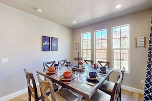 A dining area with a long table set for multiple people, surrounded by chairs. - 5BR shared pool with slide near outdoors (Washington)