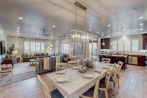 A spacious living area with a dining table set for six, a sofa, and a kitchen area with a large island. - 5 BR home with hot tub & water park PV90 (Santa Clara)