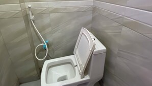 Pieni, erillinen kylpyhuone, jossa on wc ja käsienpesualta.