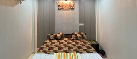A bedroom with a bed, a ceiling fan, an air conditioning unit, and a wall-mounted light fixture.