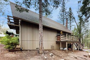 A two-story building with a large deck and a staircase leading to the upper level.