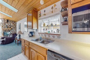 Una cocina con armarios de madera, horno empotrado y lavavajillas.
