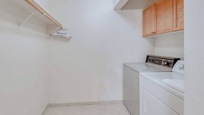 A laundry room with a washing machine, a drying rack, and wooden cabinets. - Eagle's Rest - Huntington Lake (Lakeshore)